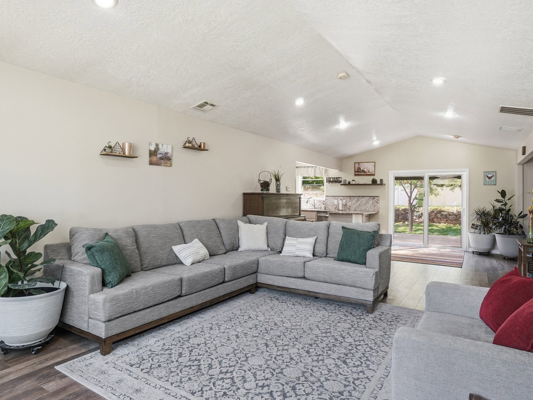 Spacious living area featuring vaulted ceilings, recessed lighting, and wood-finish flooring