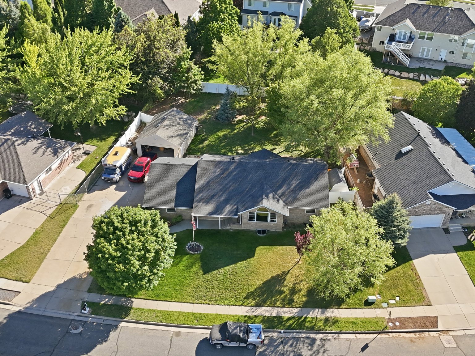 Single-story residence featuring a front lawn and mature trees