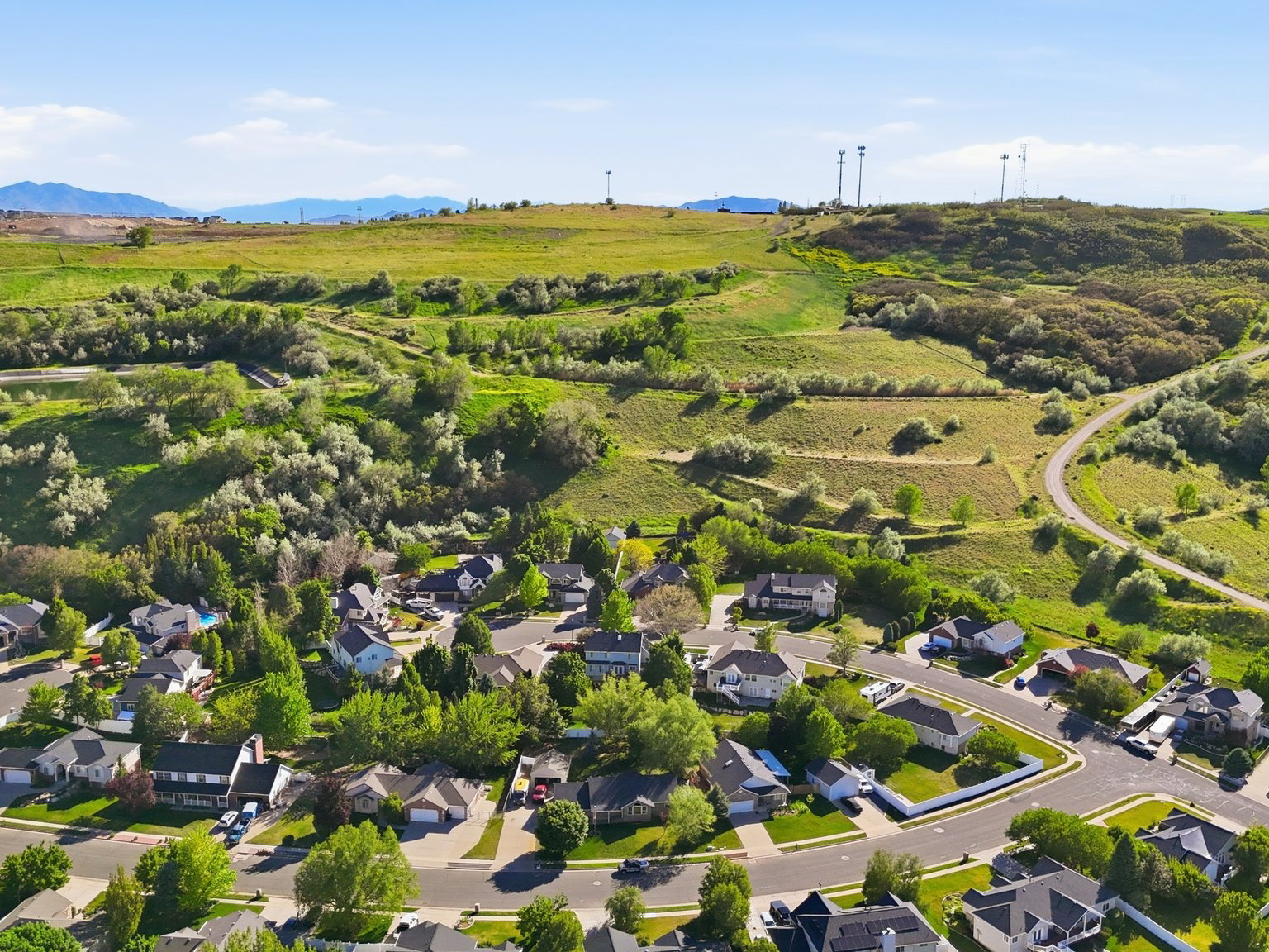 Residential neighborhood featuring curving streets, mature trees, and individual properties with green lawns