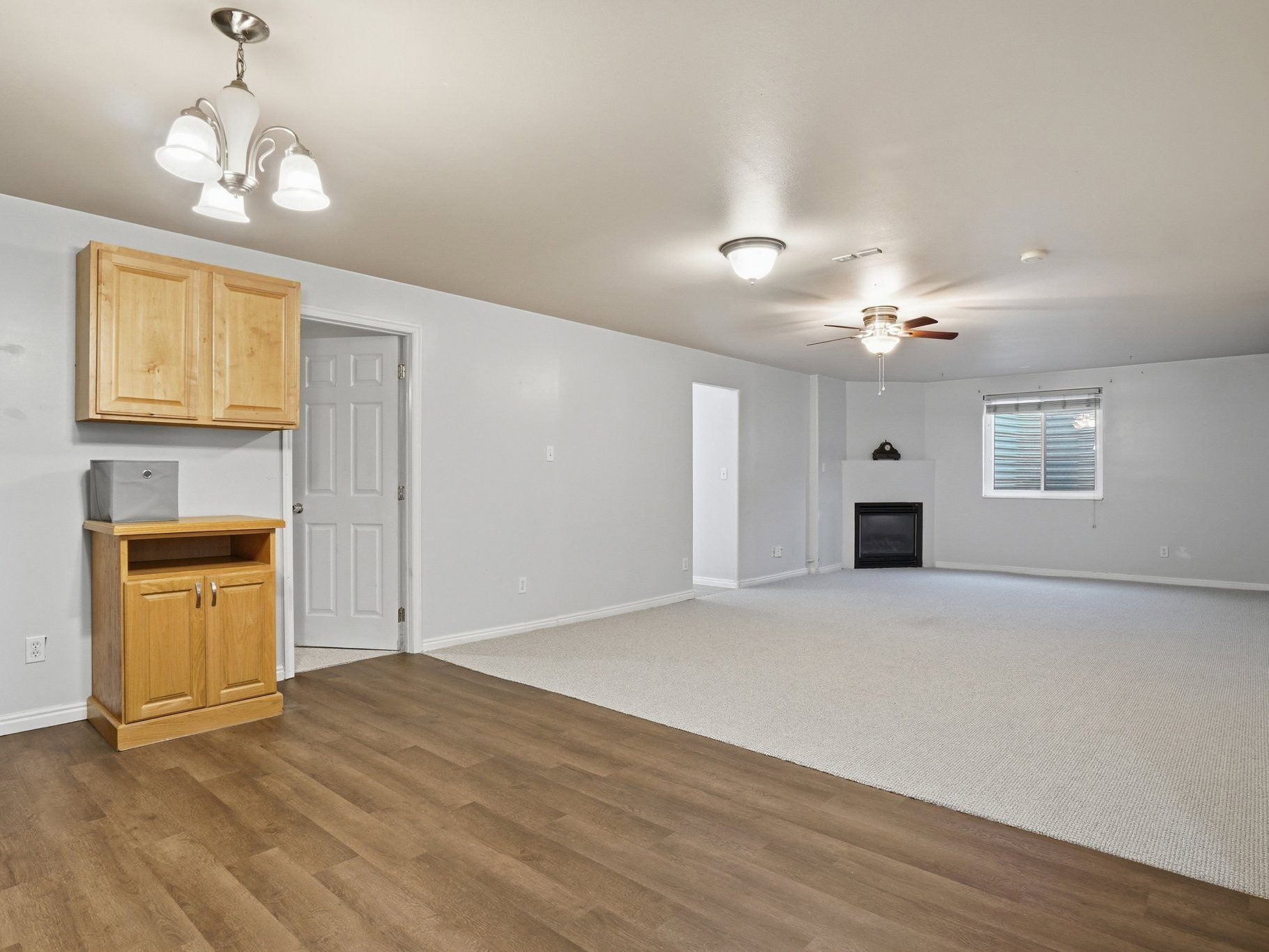 Spacious room featuring a corner-set fireplace, a ceiling fan, and recessed lighting