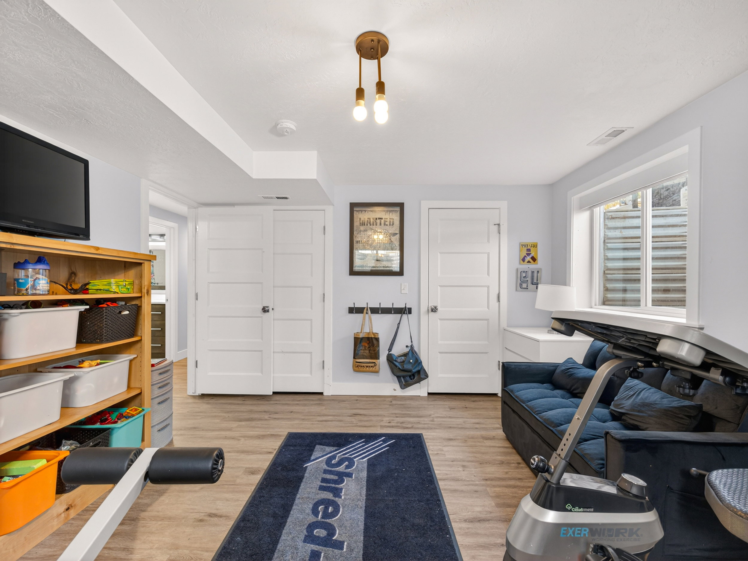Versatile space featuring wood-finish flooring, light gray walls, and white trim