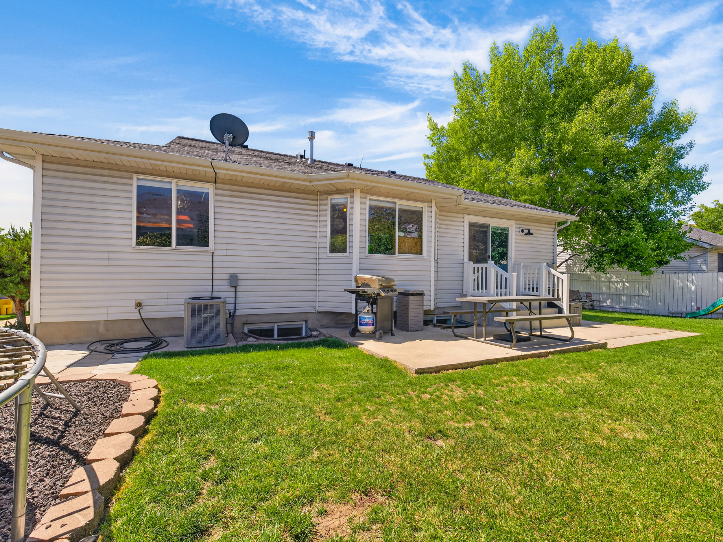 Expansive green lawn with a concrete patio