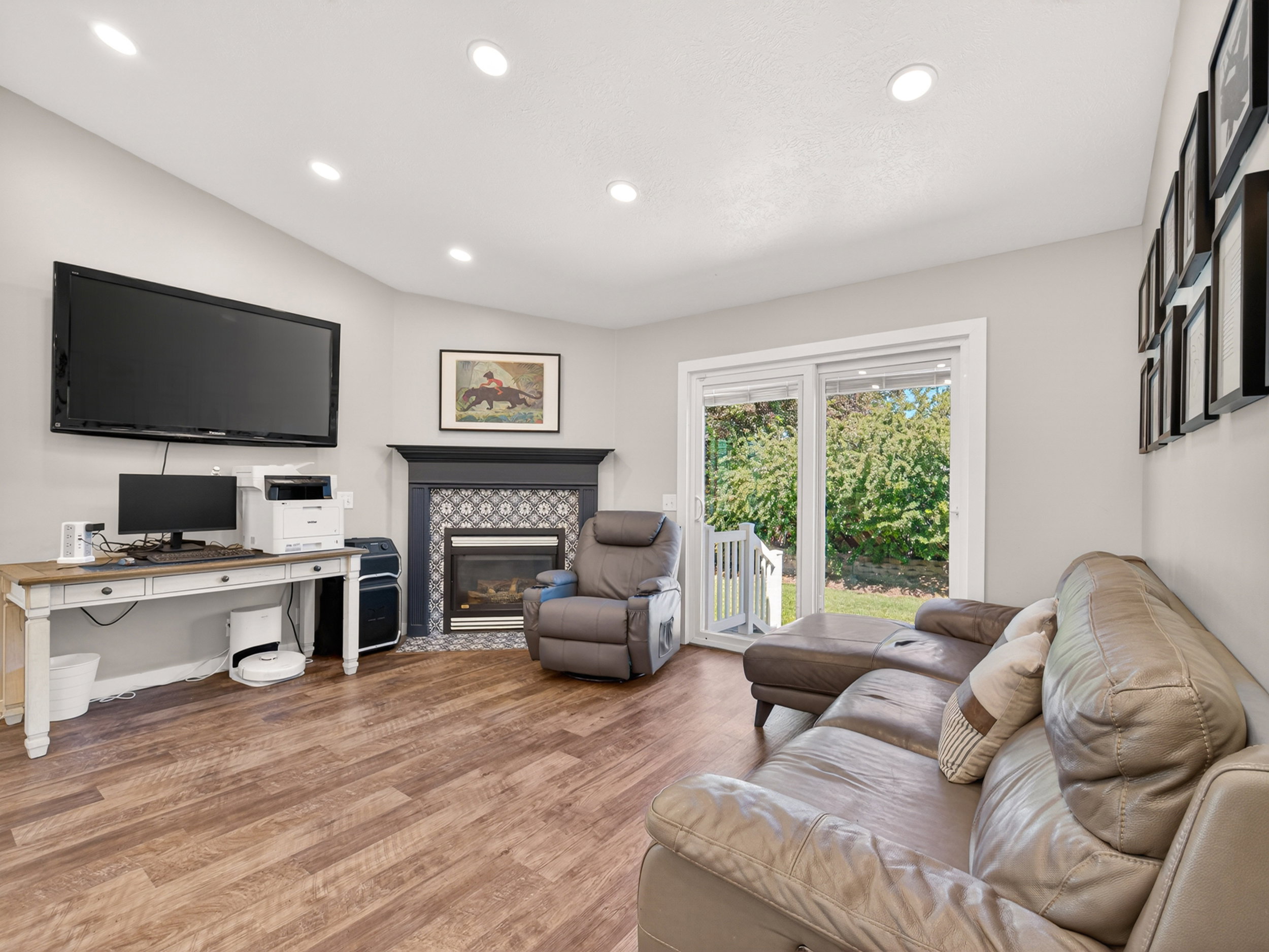 Living area featuring wood-finish flooring, recessed lighting, and a fireplace with decorative tile surround and a dark wood mantel