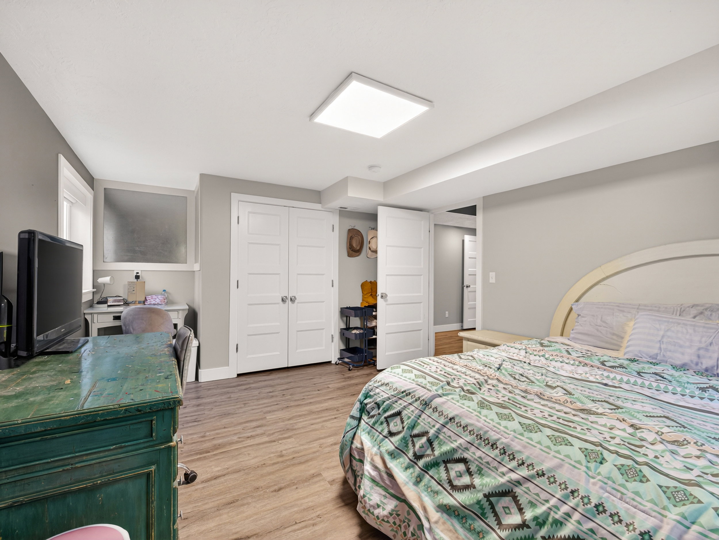 Spacious room featuring wood-finish flooring, light grey walls, and a recessed ceiling light
