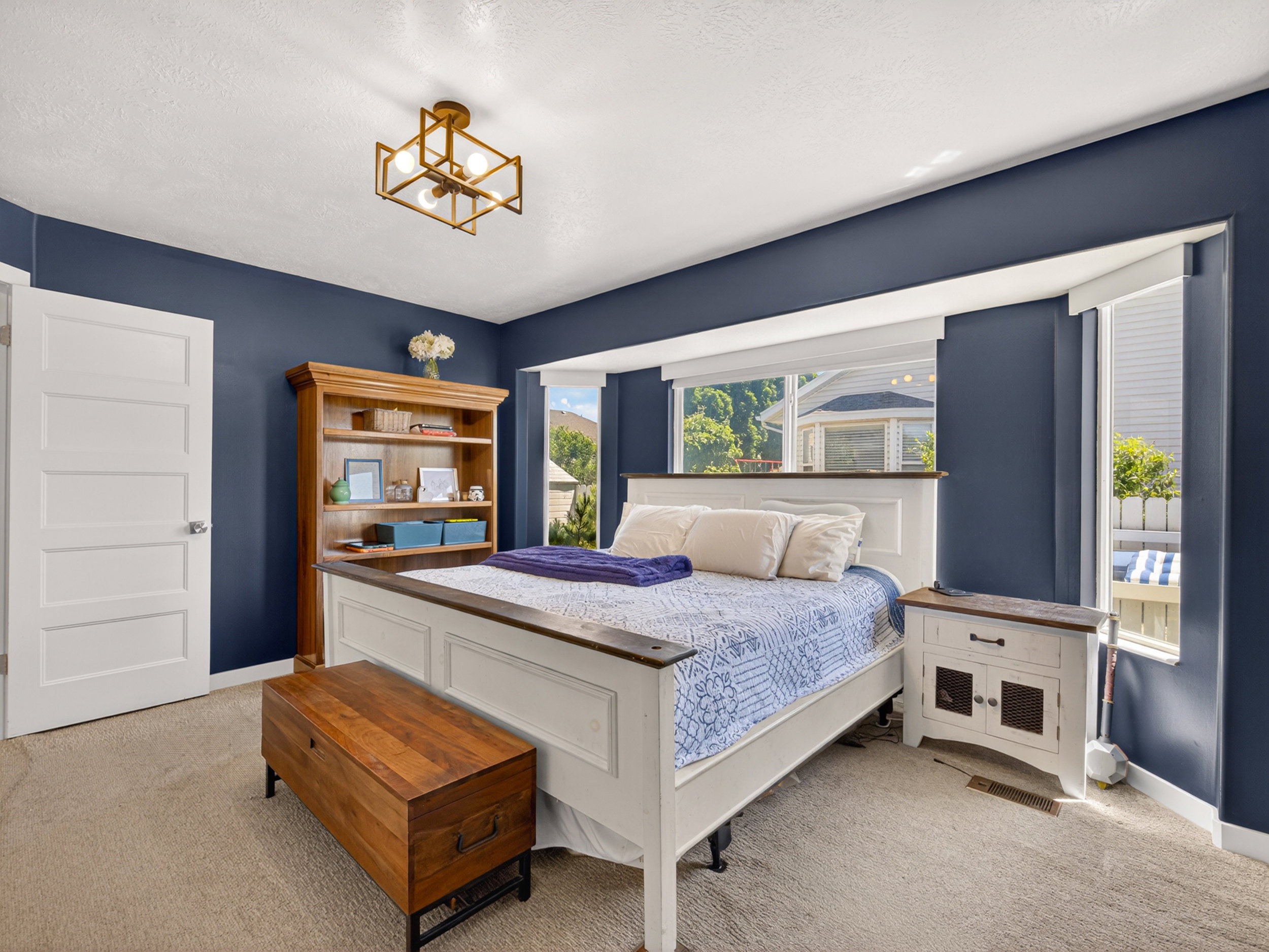 Primary bedroom featuring deep blue walls and textured carpeting