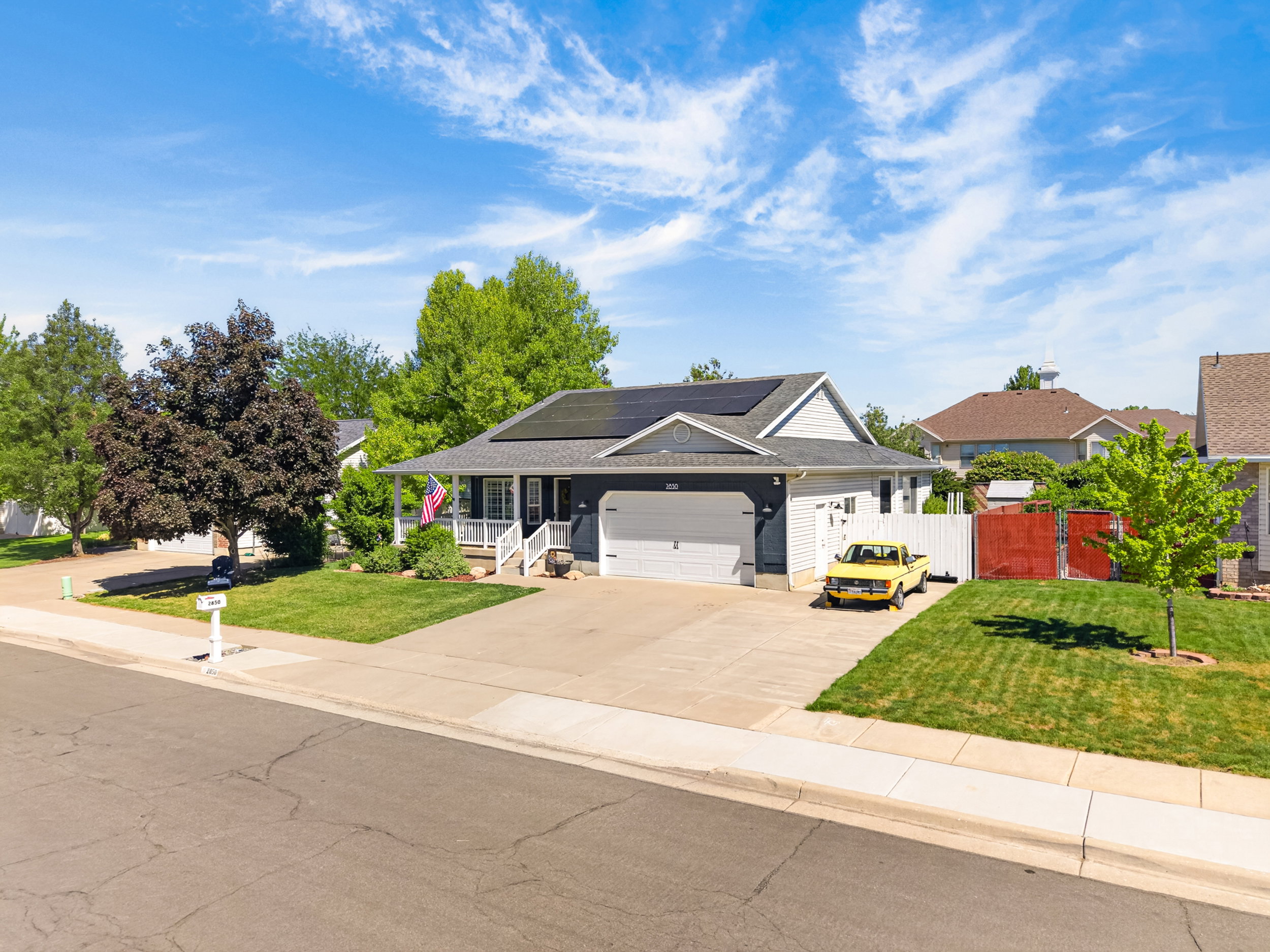 Single-story residence featuring a dark toned exterior, white trim, and a covered front porch with white railings