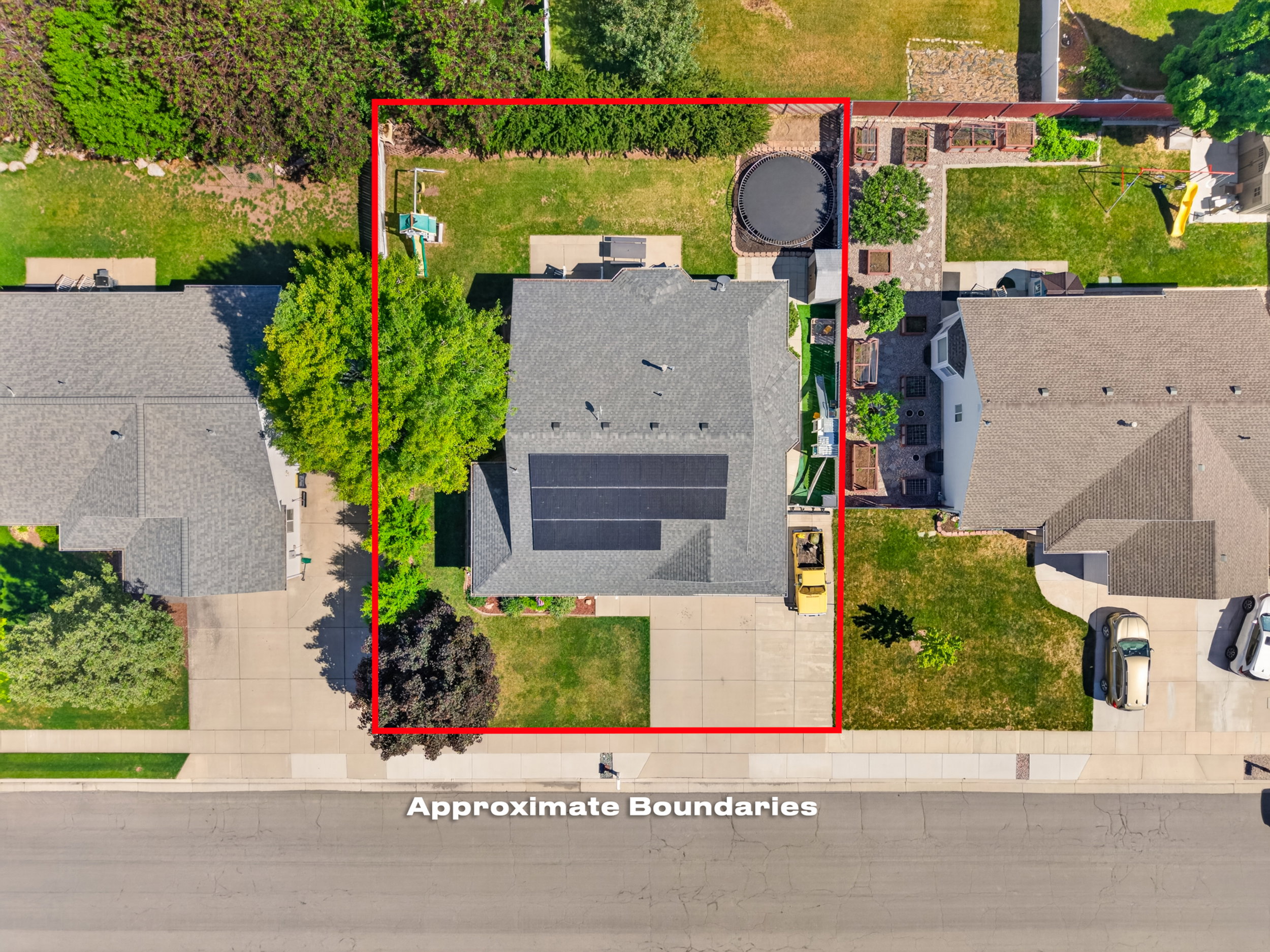Property featuring a gabled roof, solar panels, a concrete driveway, and a front yard with mature landscaping