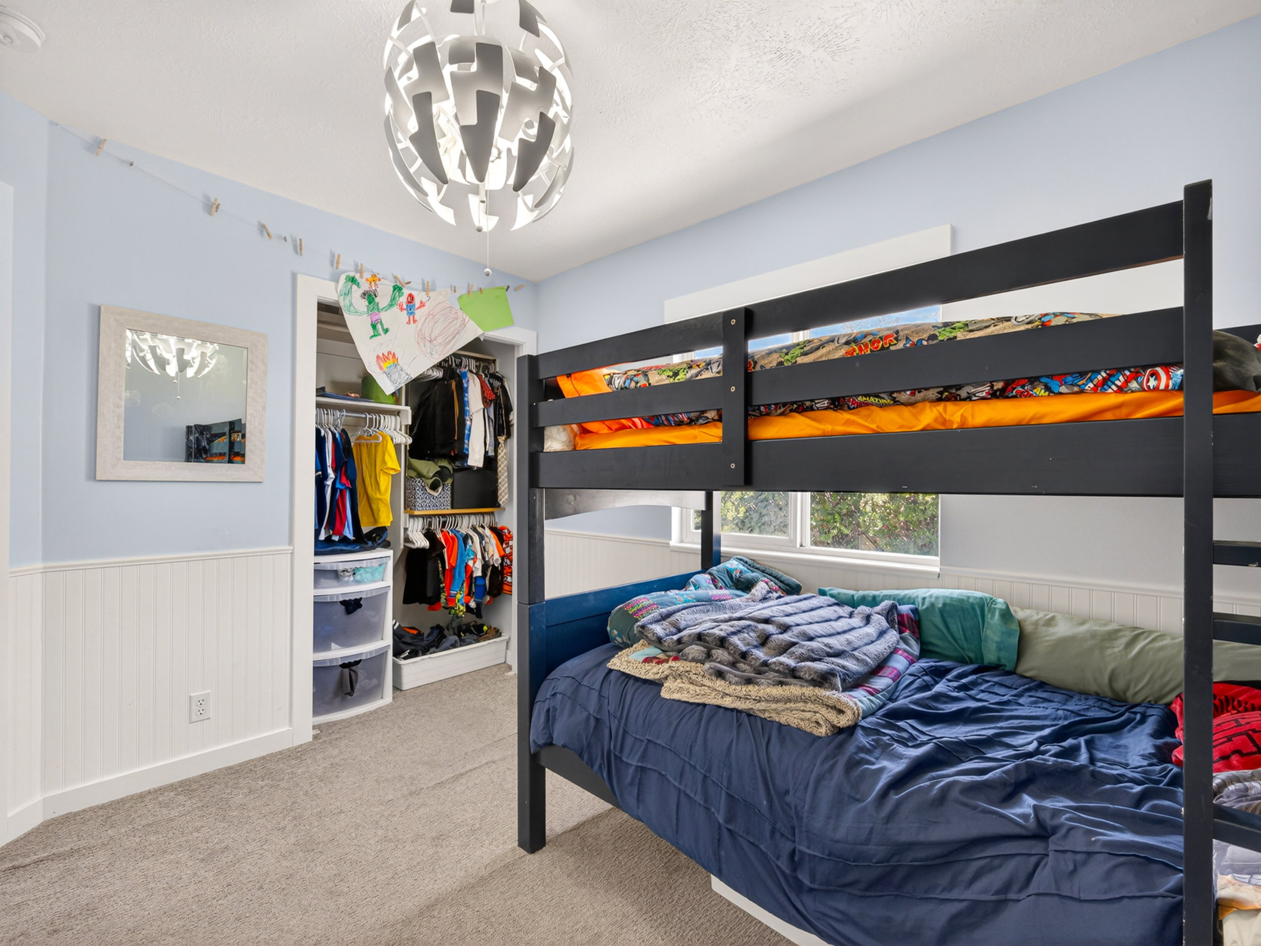 Room featuring wainscoting details, light blue wall paint, and gray carpet flooring