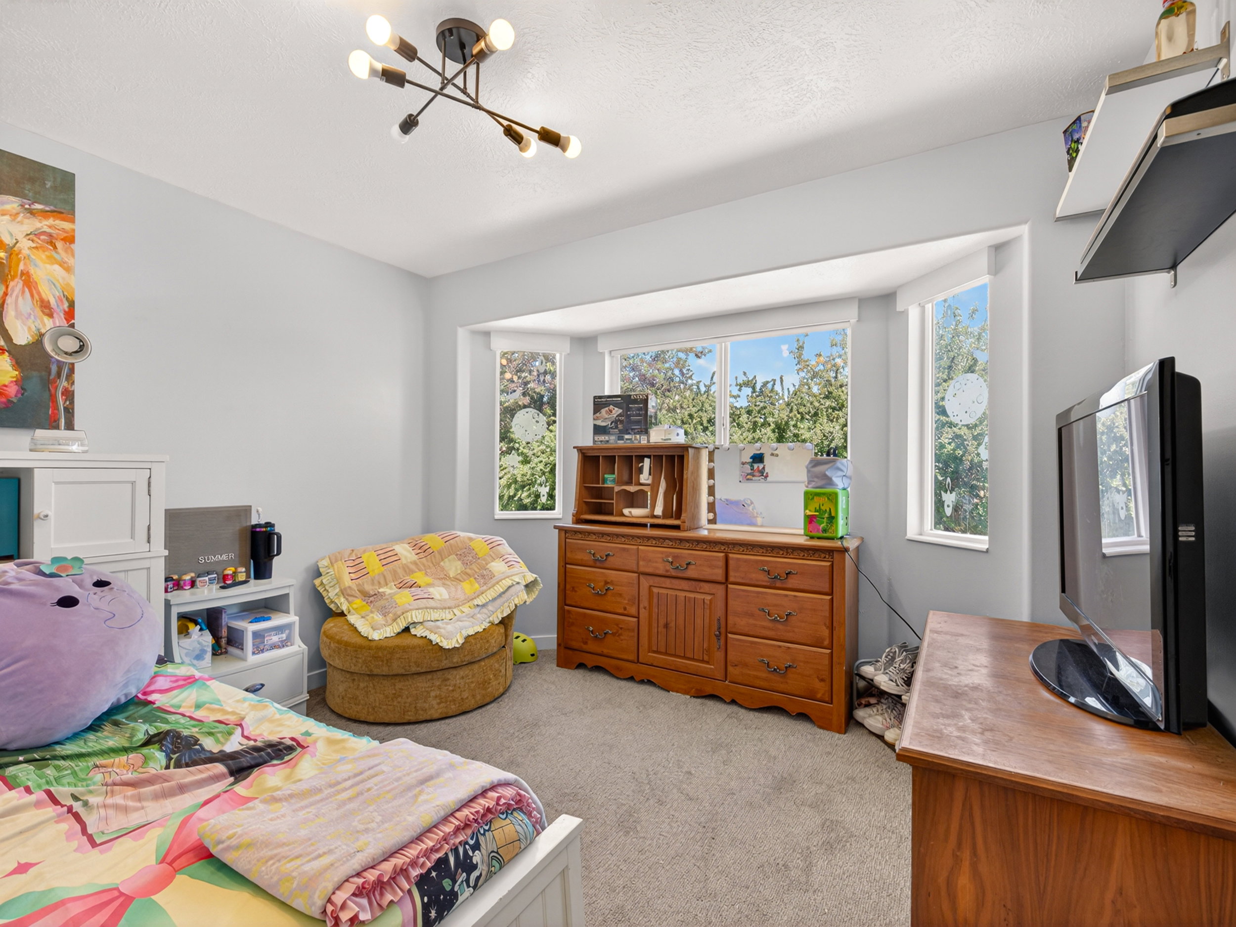 Bay window featuring multiple panels, light gray walls, and a modern ceiling light fixture