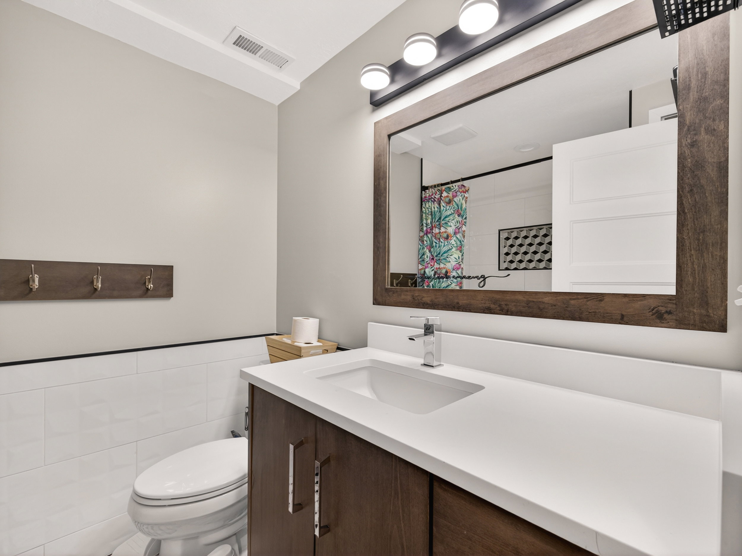 Vanity featuring a white countertop with integrated sink and chrome faucet