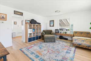 Bright living area featuring light wood-finish flooring and white painted walls