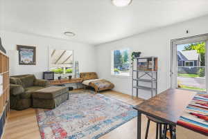 Bright interior space featuring light wood-finish flooring, white walls, multiple windows, and recessed lighting