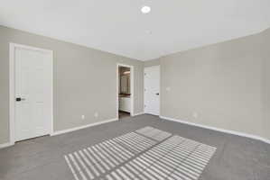 Spacious room with plush gray carpeting, neutral wall finishes, and recessed ceiling lighting