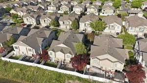 Residential community with uniform architectural styles featuring two-story homes with attached garages, individual backyard patios, and privacy fencing