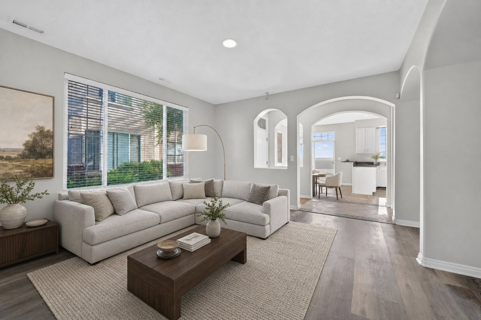 Spacious living area featuring wide plank wood-finish flooring, recessed lighting, and a large window with horizontal blinds