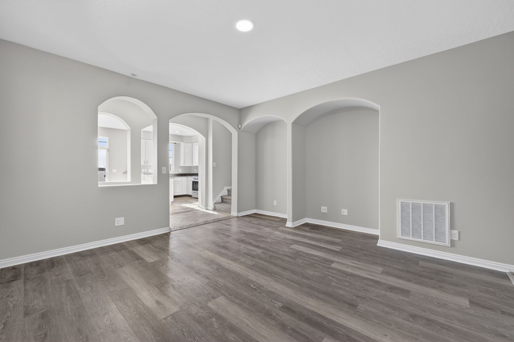 Interior space featuring wood-finish flooring, light grey painted walls, and white baseboards