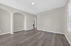 Spacious room featuring wood-finish flooring and neutral wall tones