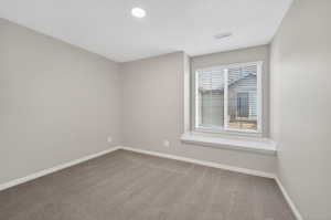 Carpeted room featuring a window with horizontal blinds and a window seat