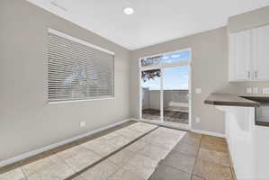 Tile flooring throughout the space, featuring a sliding glass door leading to a private outdoor area