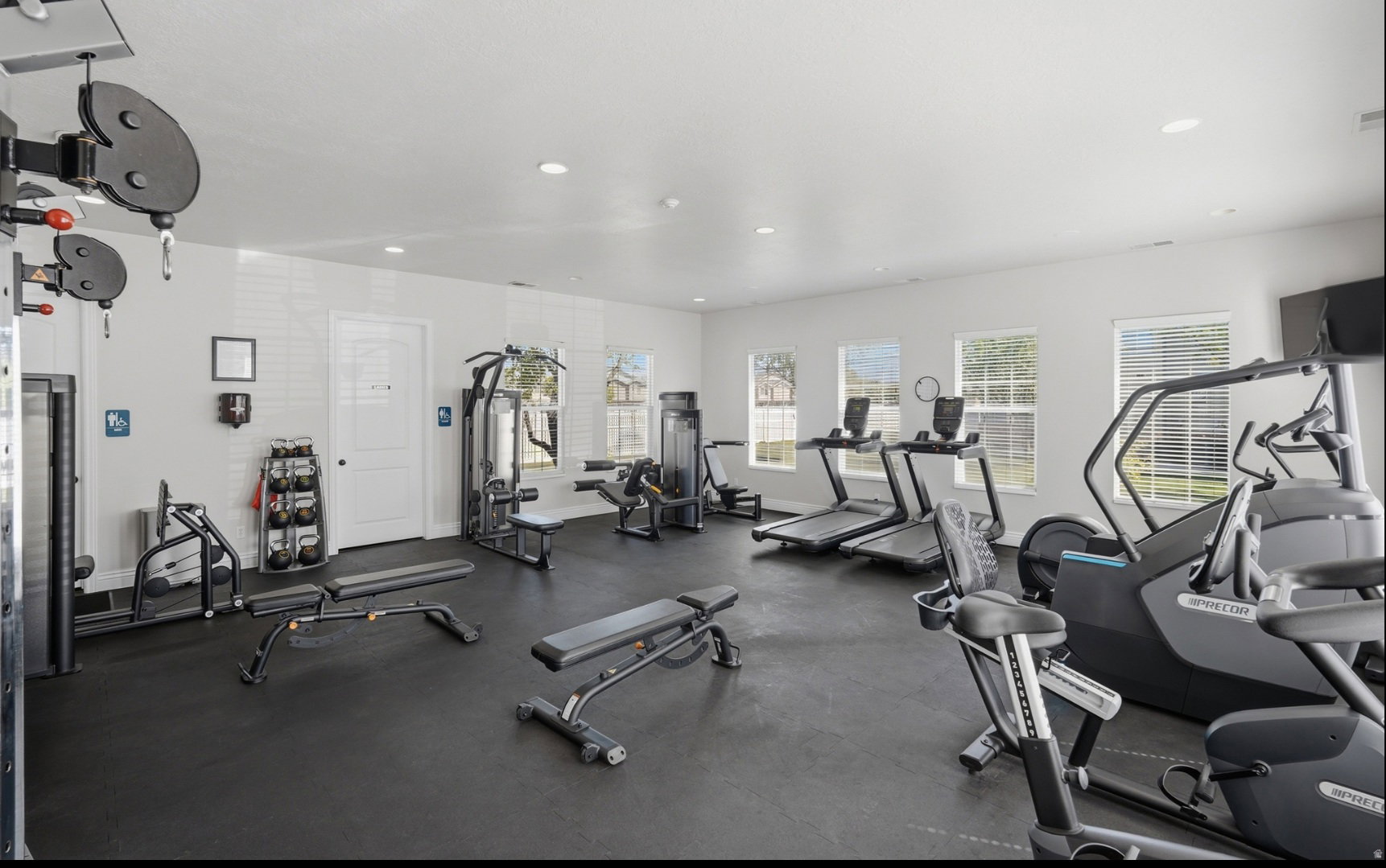 Fitness center featuring rubber flooring, recessed lighting, and multiple windows