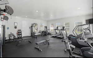 Fitness center featuring rubber flooring, recessed lighting, and multiple windows