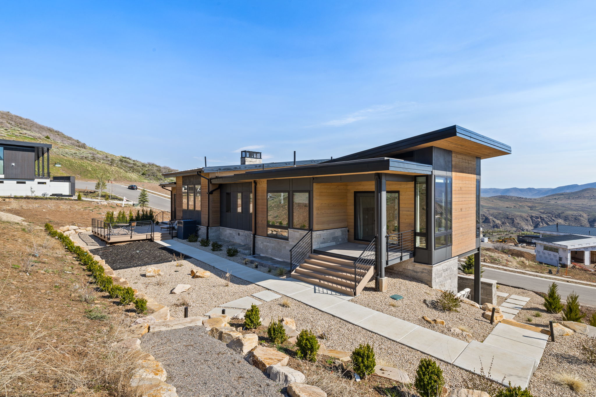 Modern exterior featuring wood-finish siding, dark trim, and expansive windows