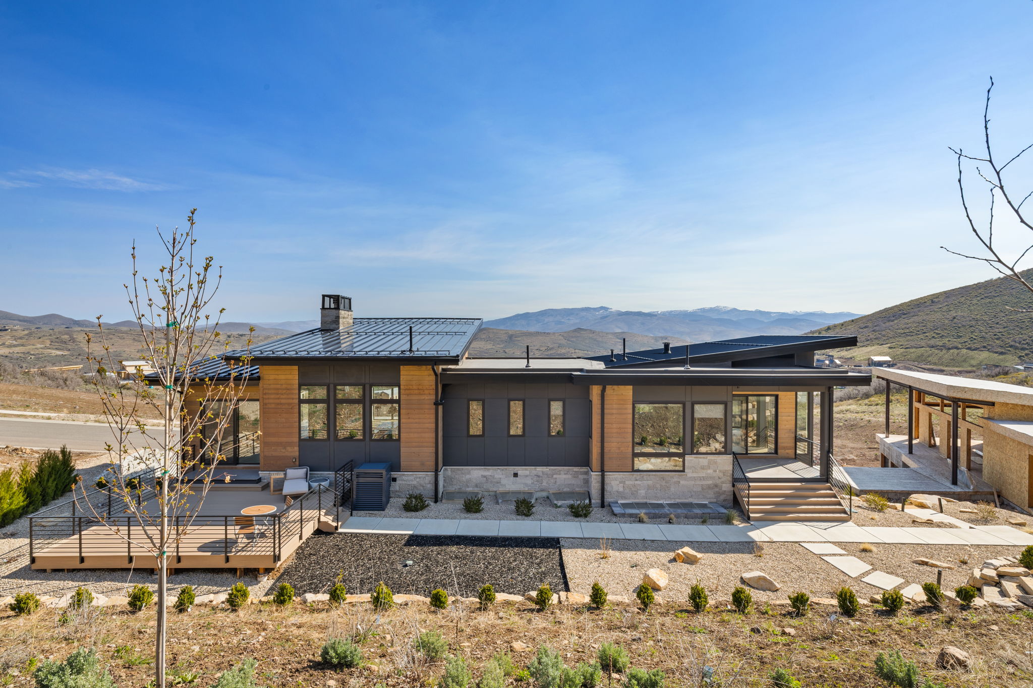 Contemporary exterior featuring dark paneling, natural wood siding, and stone accents