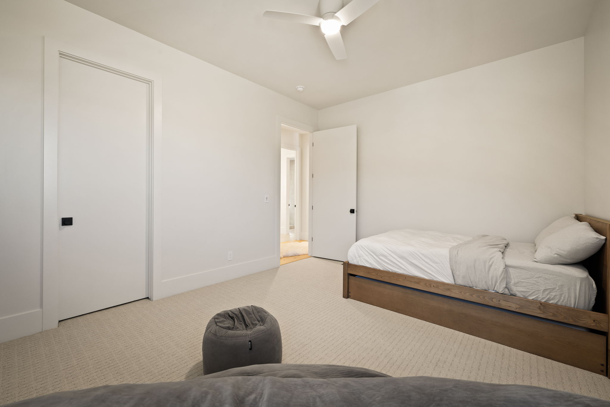 Carpeted room featuring a ceiling fan, white walls, and white trim