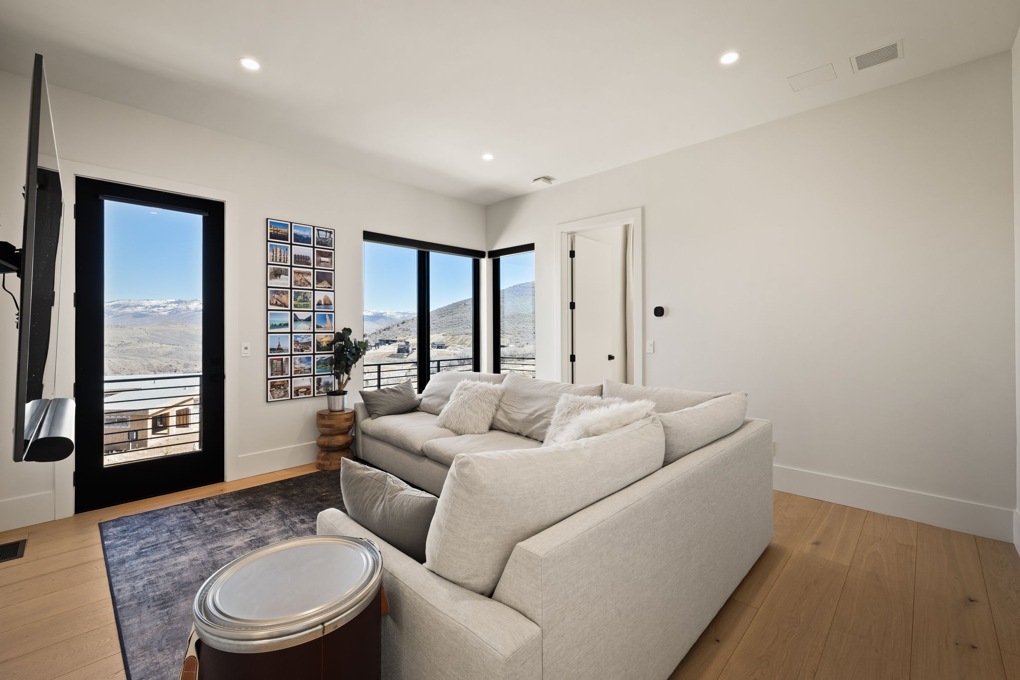 Living area featuring large windows and a glass-paneled door, offering expansive mountain scenery