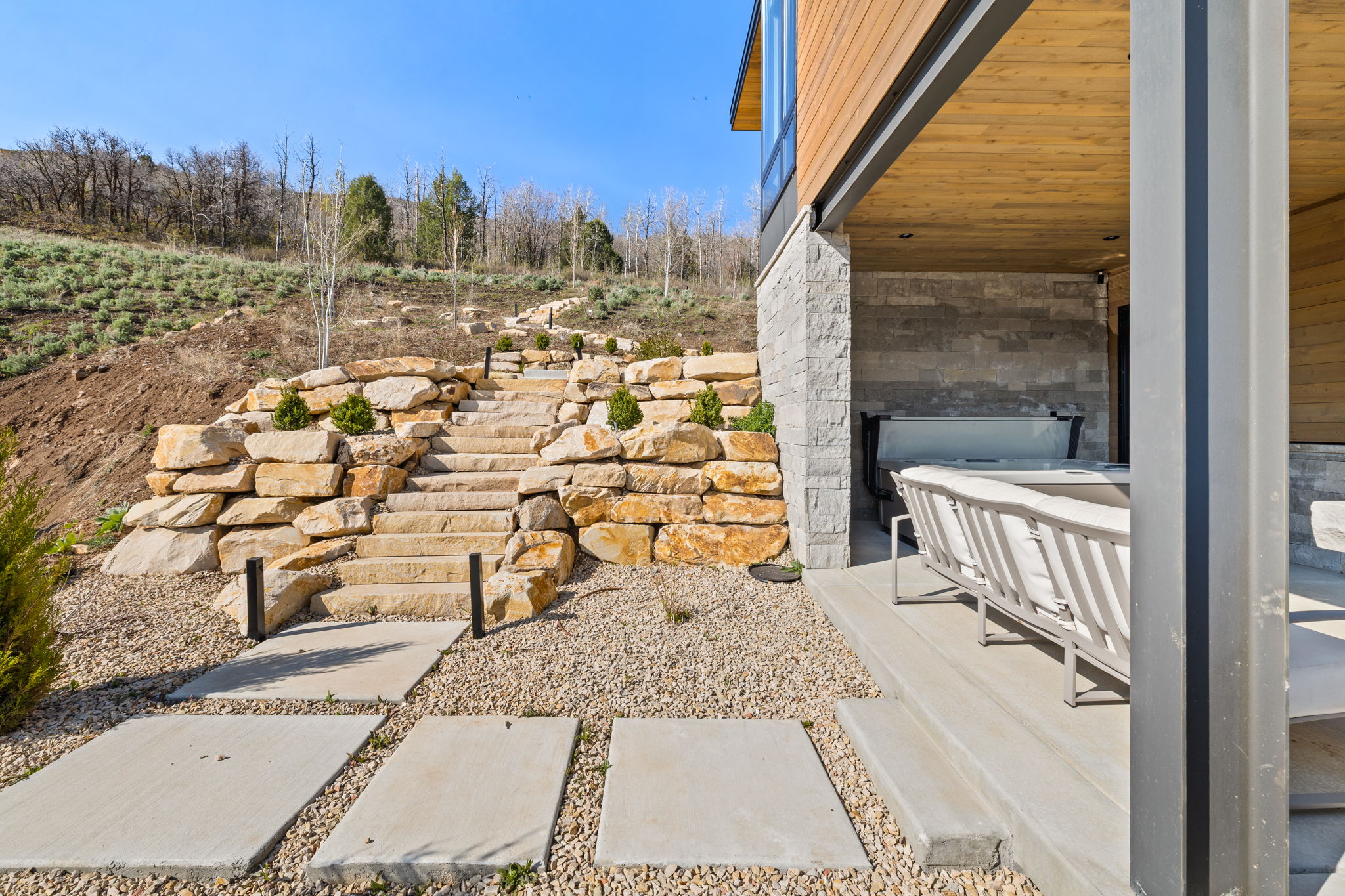 Stone retaining walls and steps complement the natural landscape