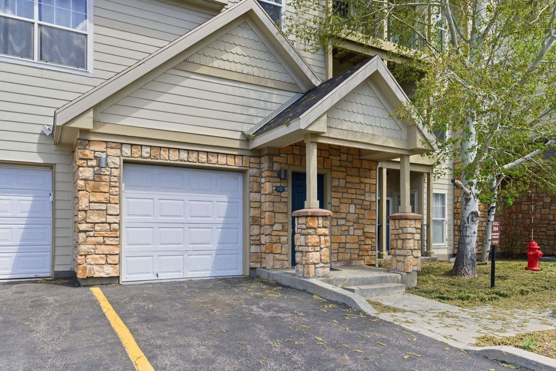 Exterior featuring stone veneer accents, horizontal siding, and multiple gabled rooflines