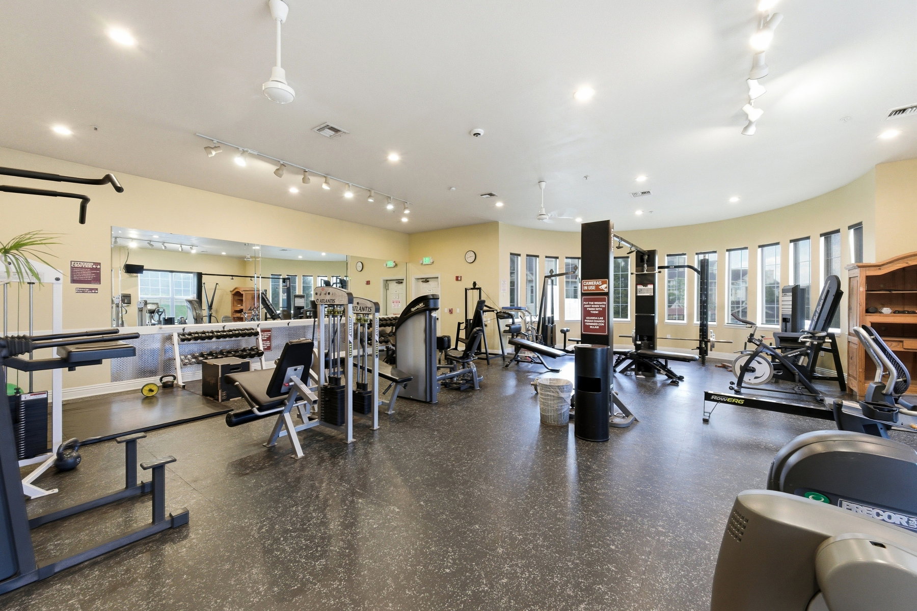 Spacious fitness center featuring a variety of exercise equipment, mirrored wall, recessed lighting, and ceiling fans