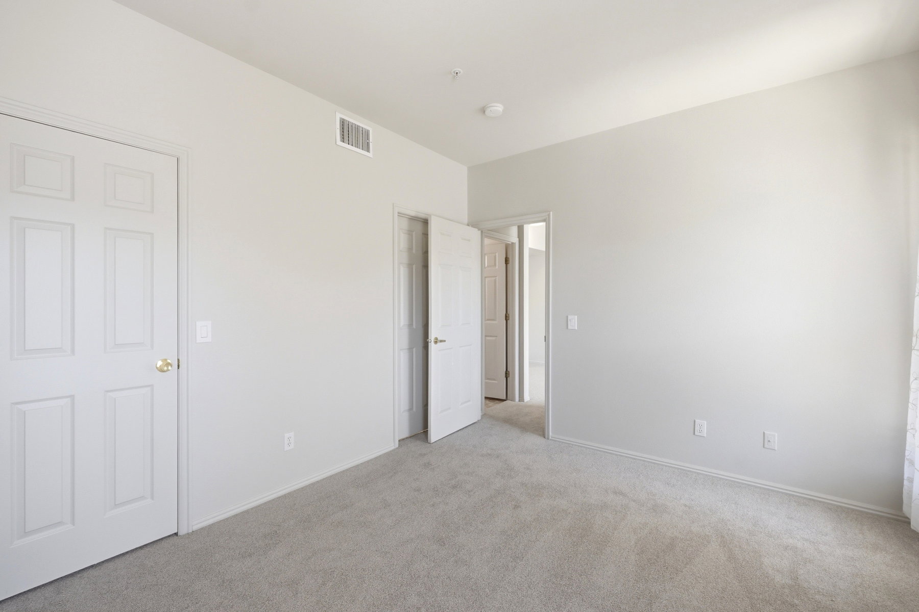 Neutral-toned room featuring light gray carpeting and white painted walls