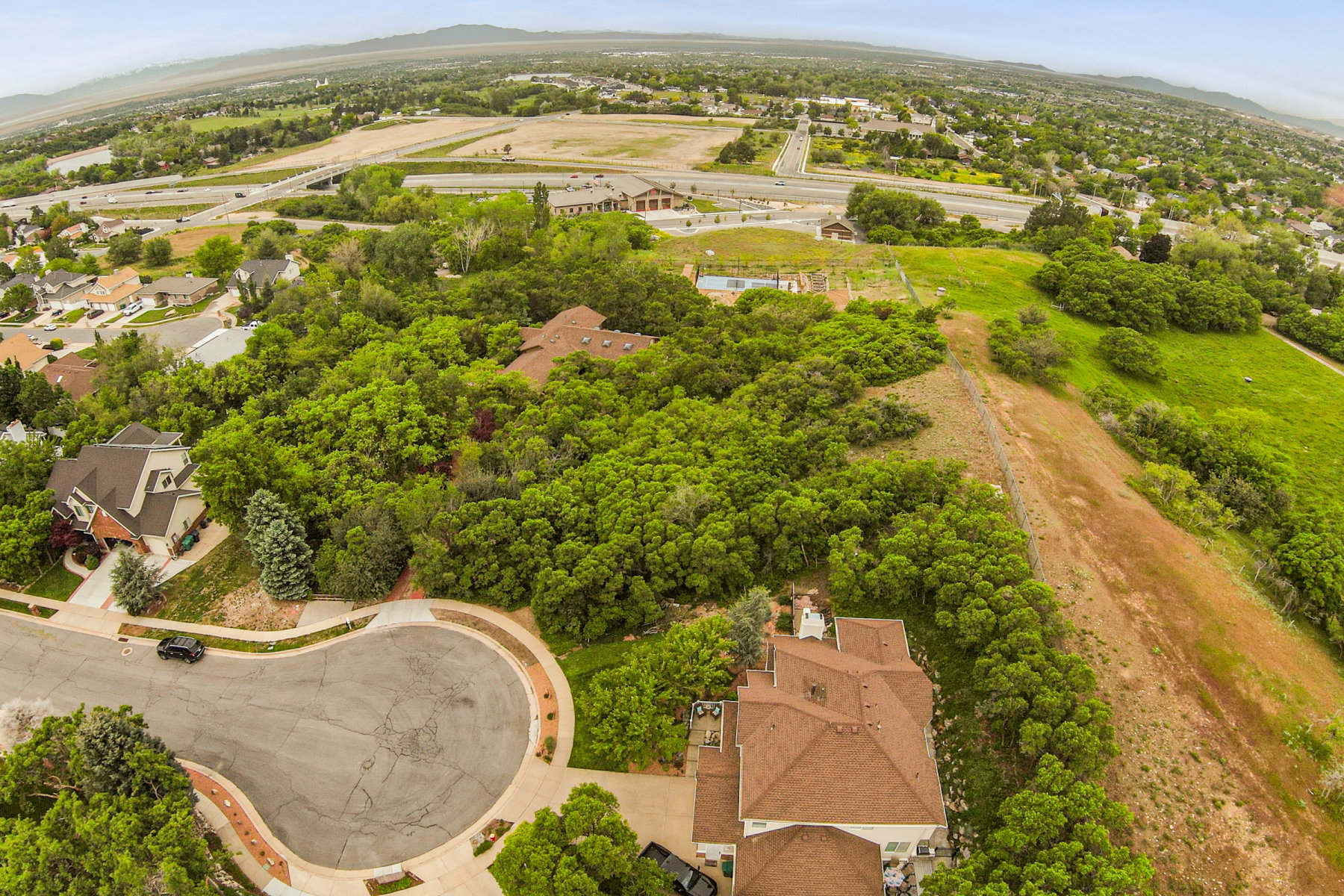 Expansive aerial view showcasing a cul-de-sac with mature landscaping and surrounding residential properties