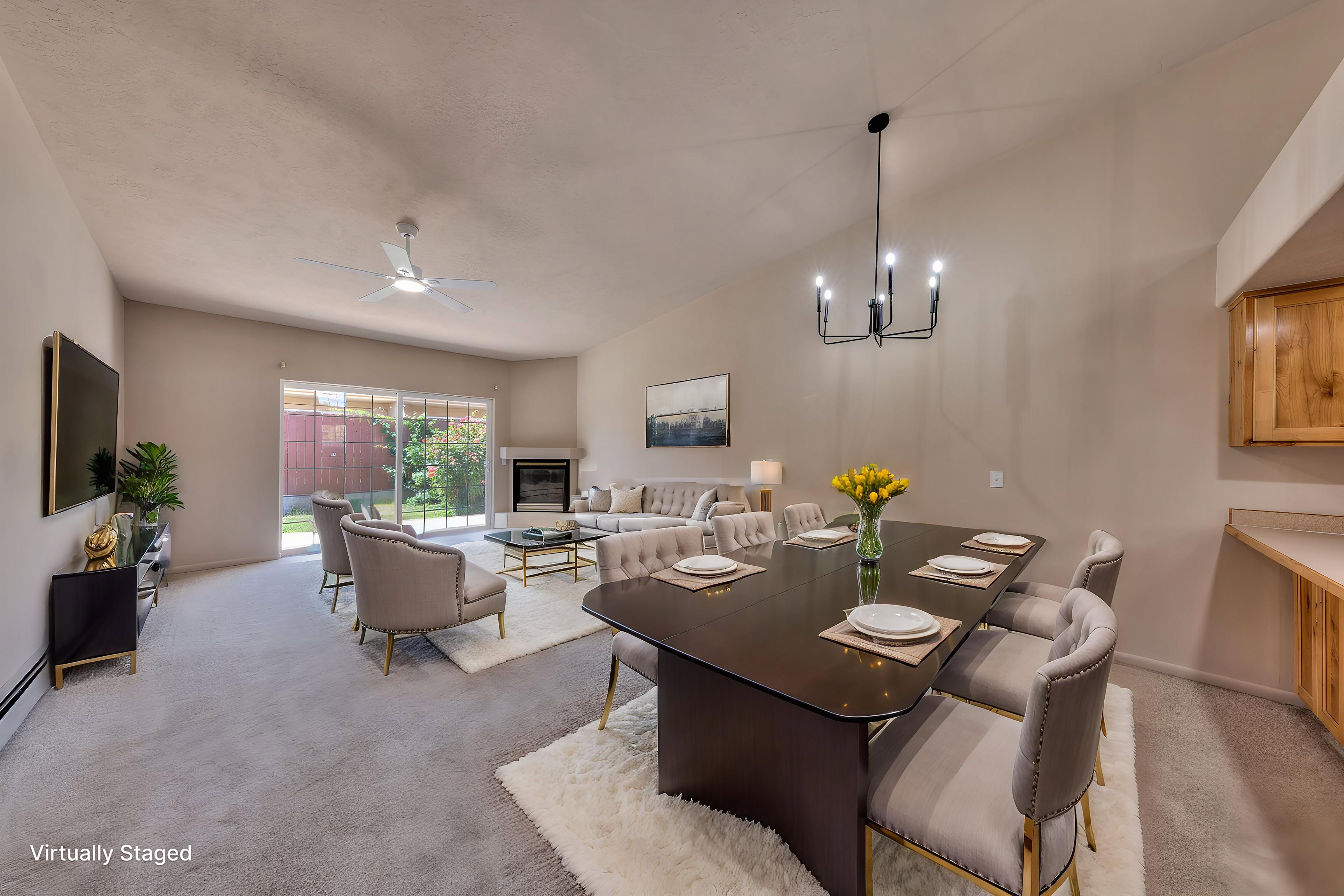 Vaulted ceilings elevate this open-concept living area with a fireplace and sliding glass doors