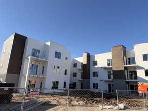 Multi-story building featuring white horizontal siding and brown vertical siding accents