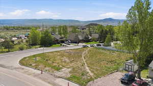 Elevated parcel featuring natural ground cover, distant mountain ranges, and a paved road frontage