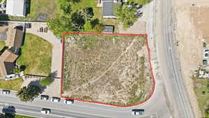 Expansive vacant lot with a perimeter outlined in red, featuring direct access to a paved road