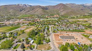 Expansive residential area with a mix of established homes and new construction, set against a backdrop of mountains with visible snow caps