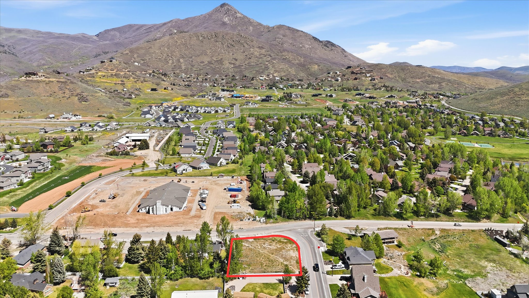 Vacant lot outlined in red, featuring direct road frontage and a mountain backdrop