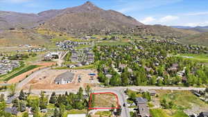Vacant lot outlined in red, featuring direct road frontage and a mountain backdrop