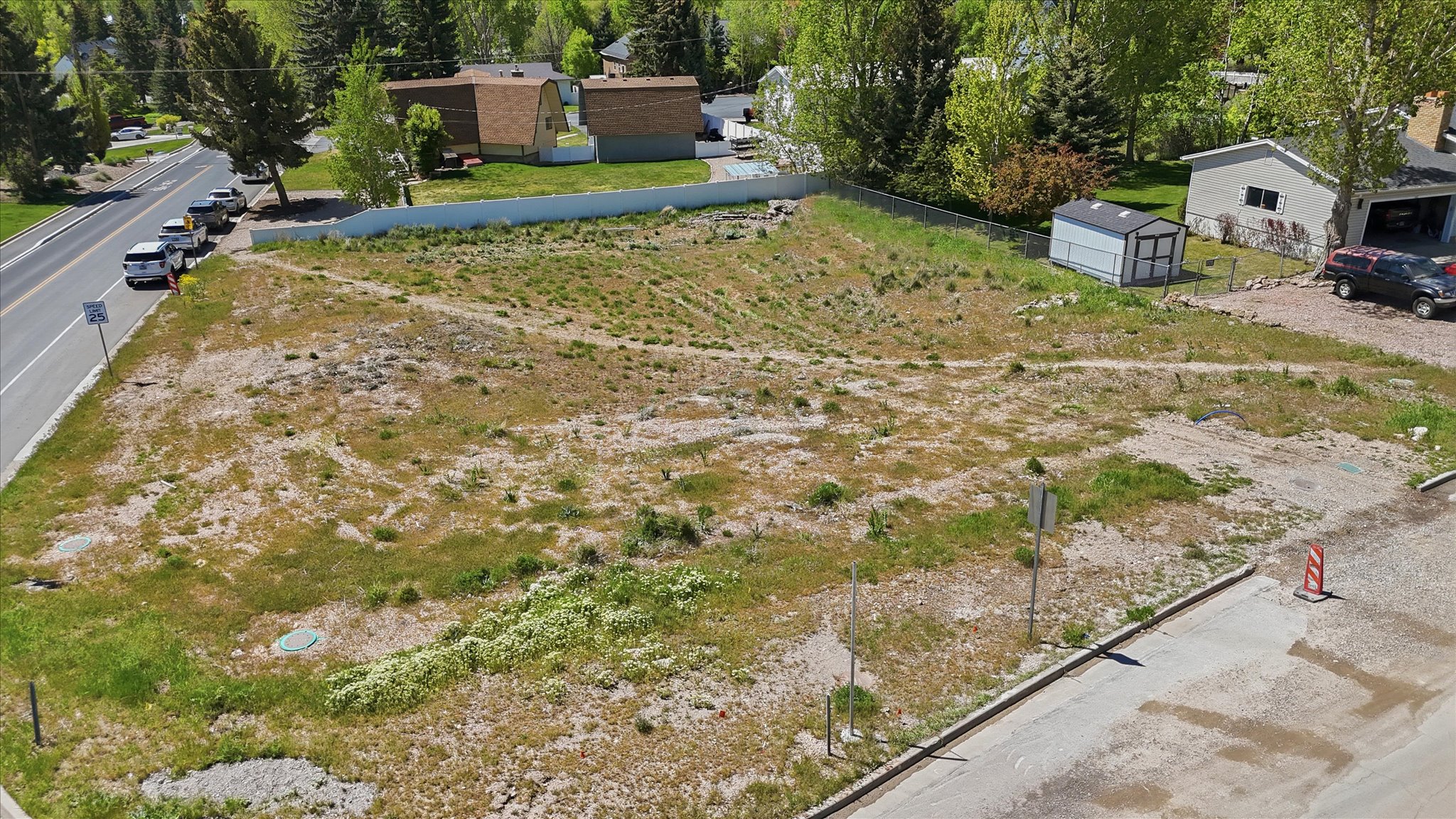 Expansive undeveloped lot featuring varied terrain and mature trees bordering the property