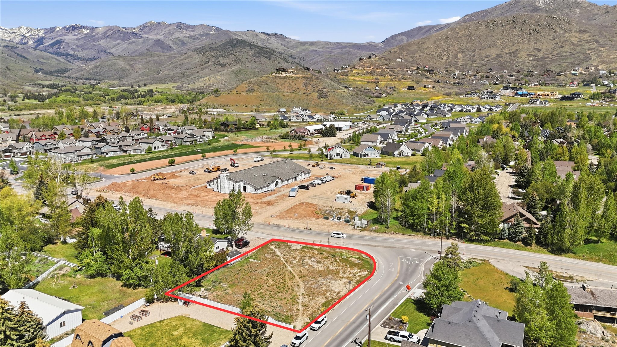 Corner lot property featuring a defined boundary, direct road frontage, and a surrounding residential area