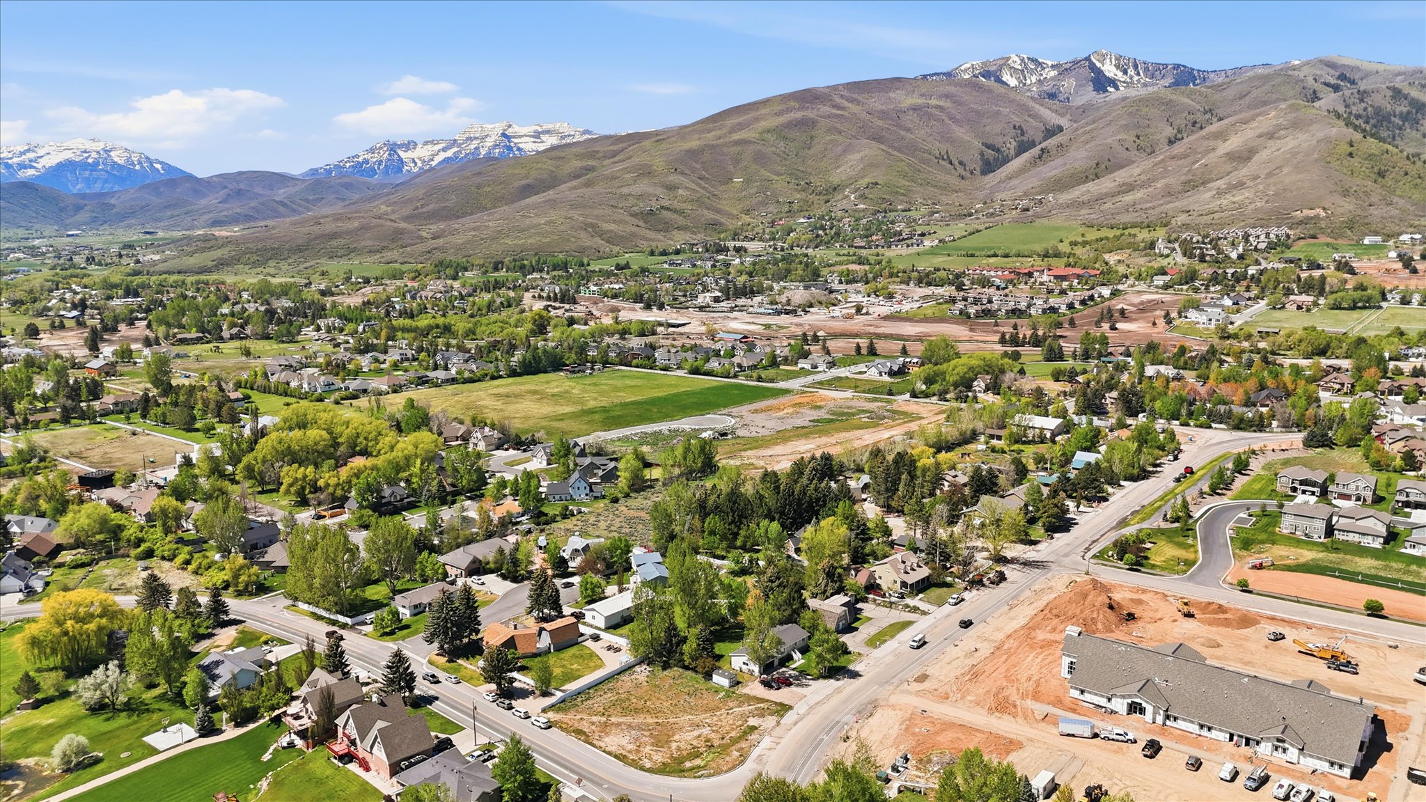 Expansive mountain scenery framing a community with residential properties and open green spaces