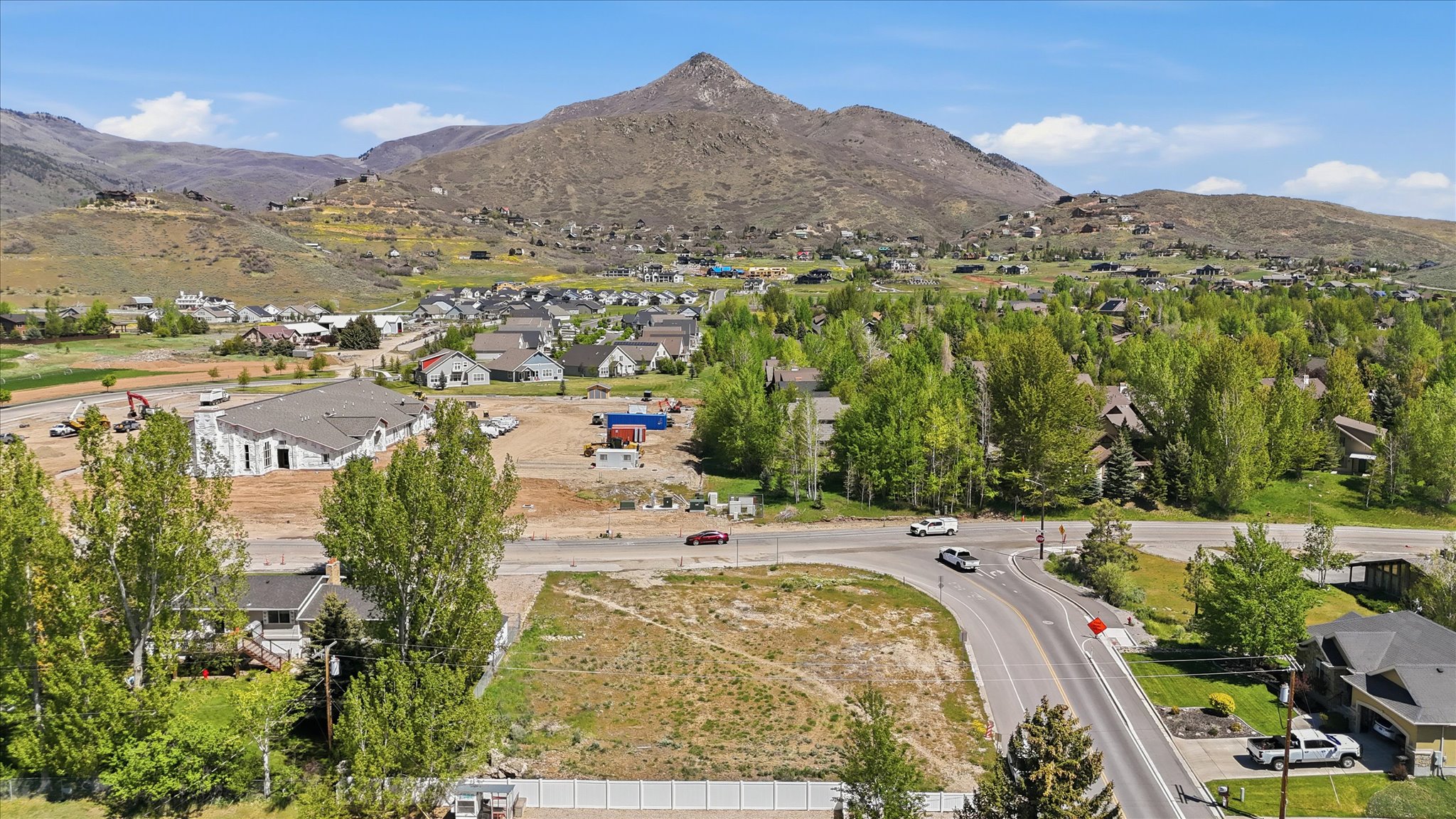Expansive residential parcel featuring a clear building site, adjacent to established homes and a developing neighborhood
