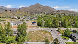 Expansive residential parcel featuring a clear building site, adjacent to established homes and a developing neighborhood
