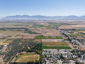 Expansive aerial view showcasing mountainous terrain, agricultural land, and residential clusters