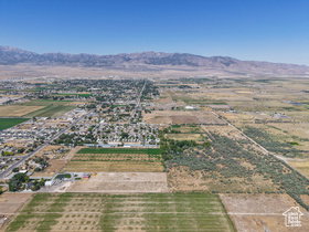 Expansive land parcel featuring a mix of agricultural fields and undeveloped natural terrain