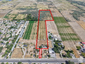 Expansive undeveloped land parcel with varied terrain, including cultivated fields and wooded areas