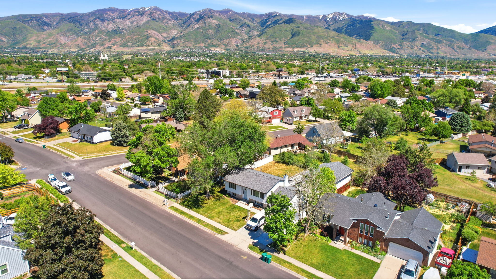 Residential neighborhood featuring established homes and mature trees, set against a backdrop of distant mountains
